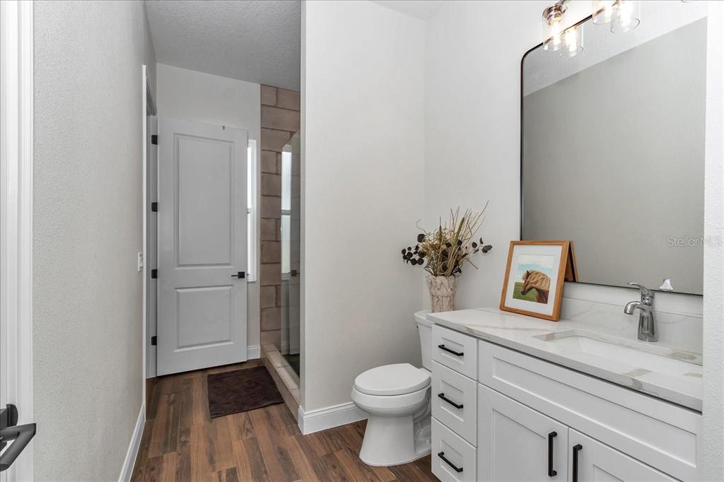 1631 West Highway 329 Citra, FL 32113 - Photo 62 of 82 a bathroom with a granite countertop sink toilet a large mirror a vanity and shower