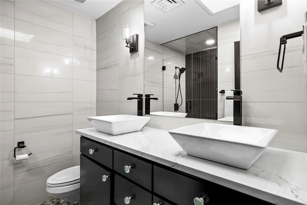 1300 Montclair Street Longview, TX 75601 - Photo 21 of 39 Full bathroom with double vanity, tile walls, and tiled shower