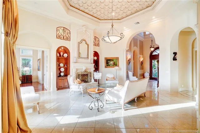 a living room with furniture a chandelier and a dining table