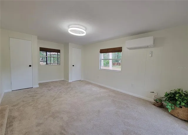 a view of a livingroom with a computer on a desk and a window