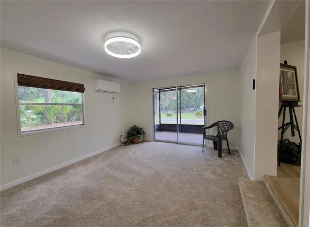 an empty room with wooden floor mirror and windows