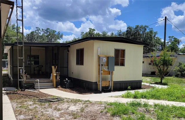 a view of a house with yard and sitting area