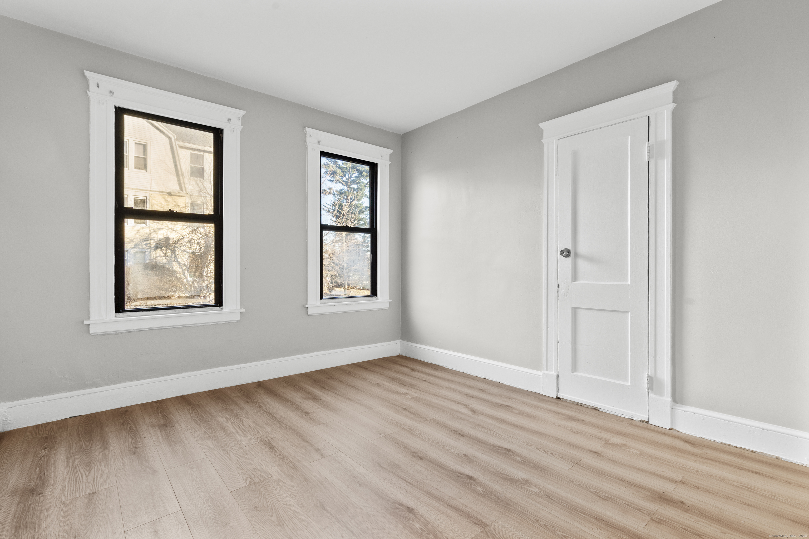 141 Draher Street Waterbury, CT 06708 - Photo 12 of 20 an empty room with wooden floor and windows