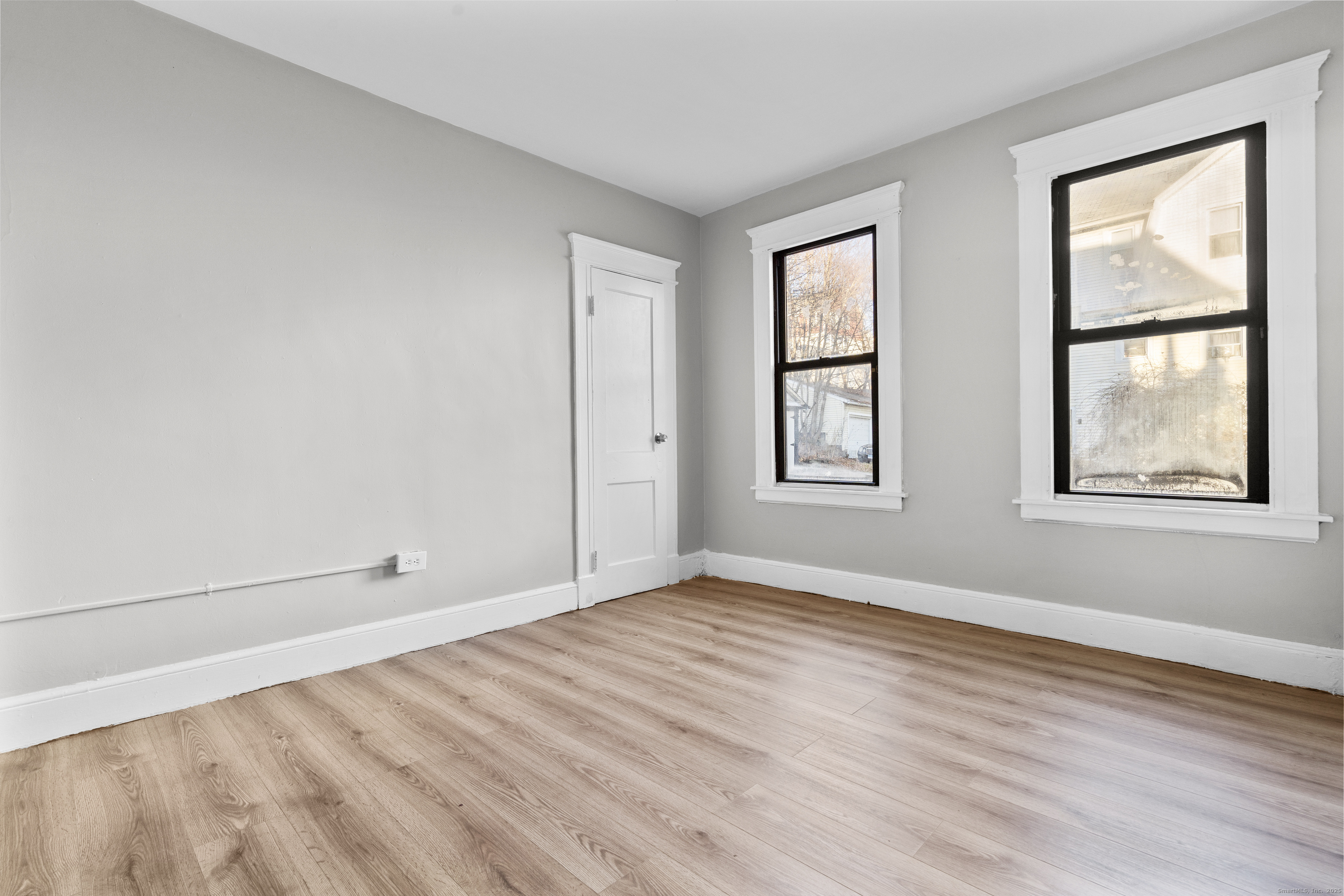 141 Draher Street Waterbury, CT 06708 - Photo 15 of 20 an empty room with wooden floor and windows