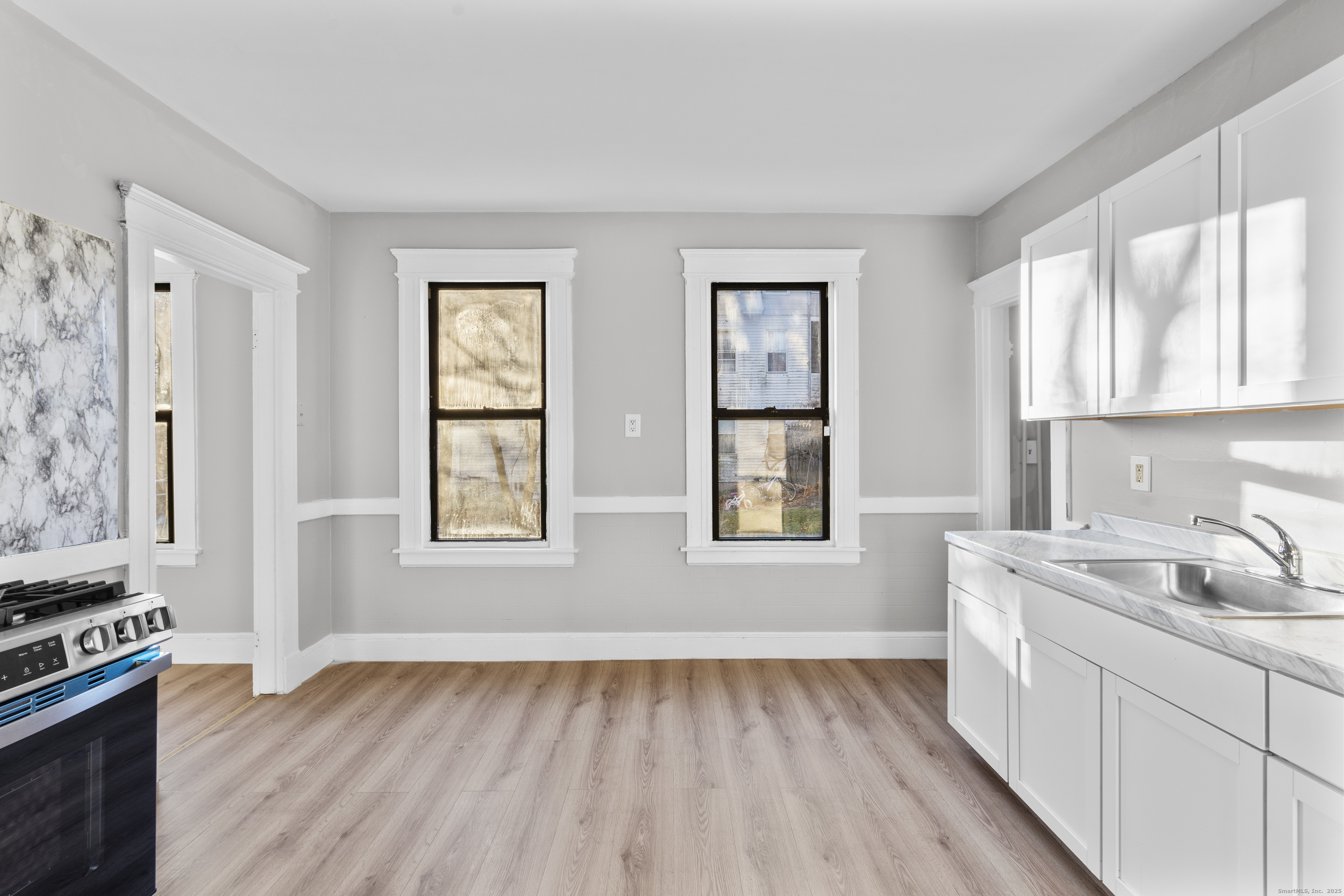 141 Draher Street Waterbury, CT 06708 - Photo 3 of 20 a kitchen with a sink wooden floor and a window