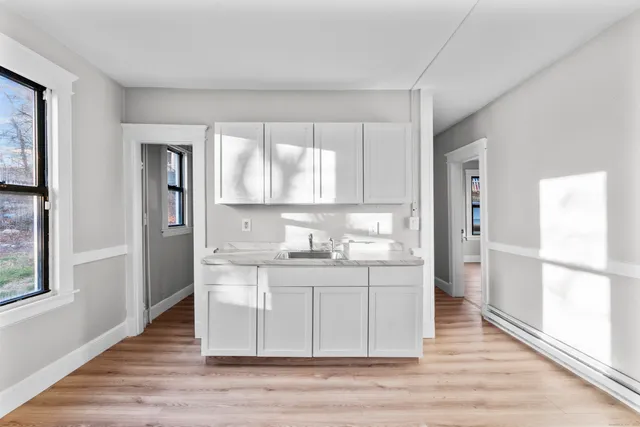 a kitchen with granite countertop a refrigerator and a stove top oven