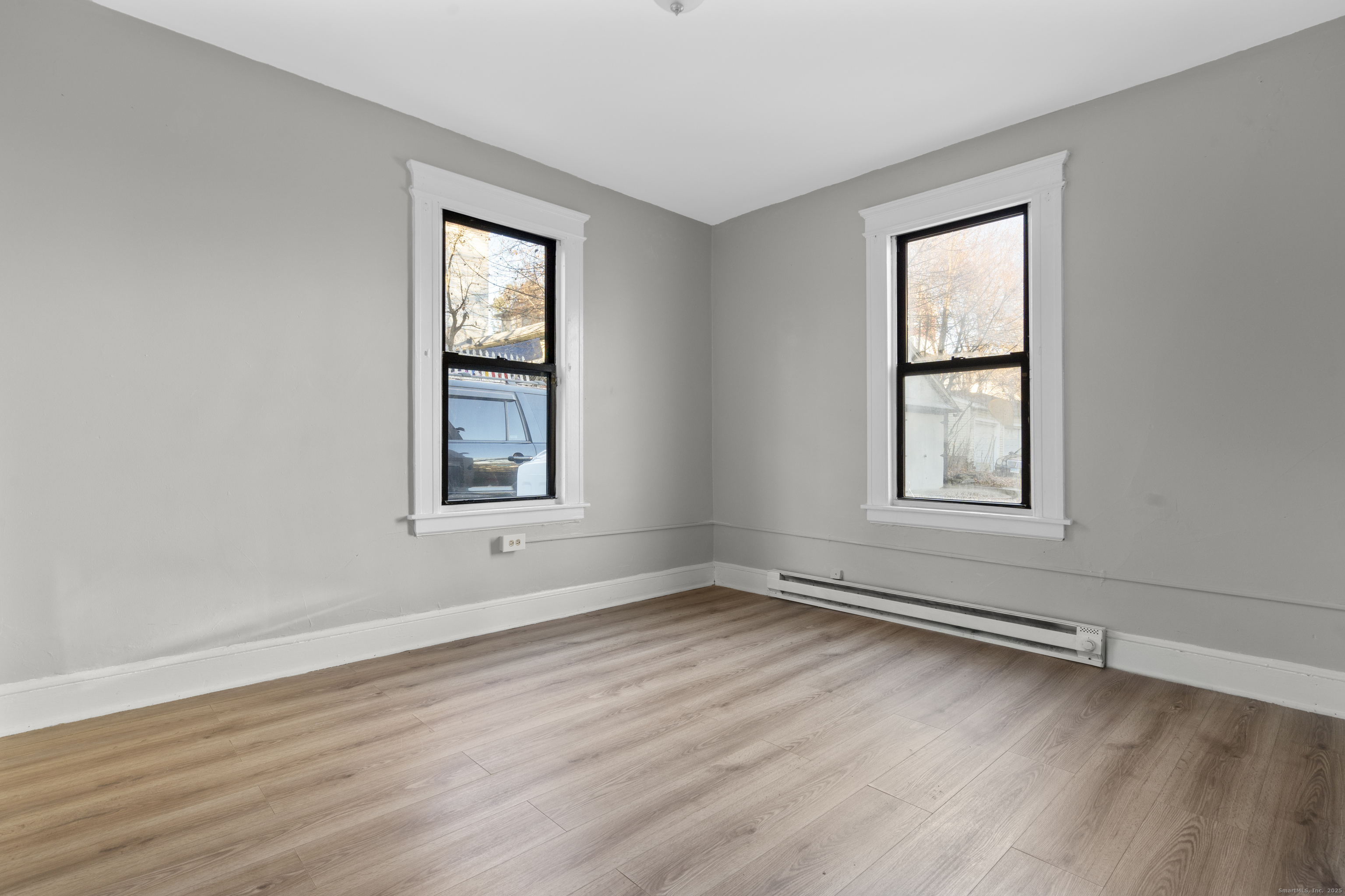 141 Draher Street Waterbury, CT 06708 - Photo 6 of 20 an empty room with wooden floor and windows