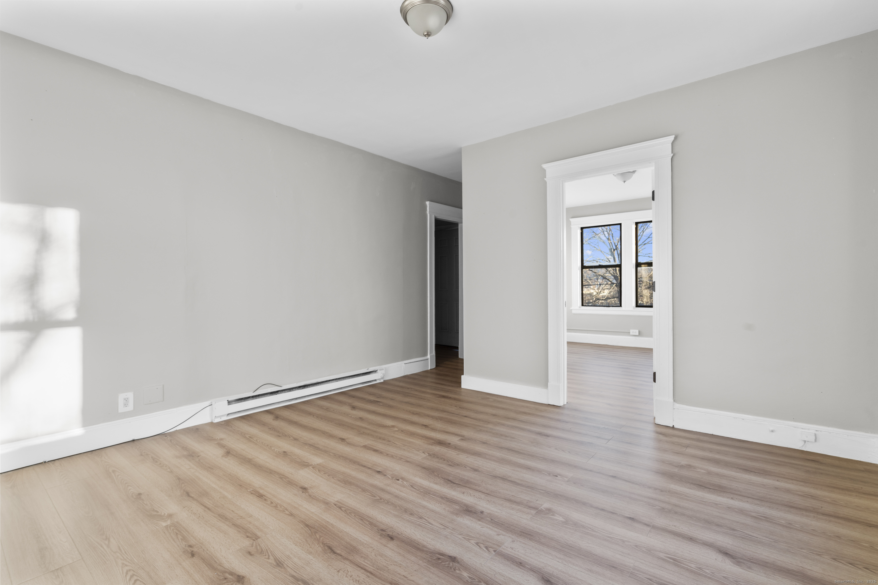 141 Draher Street Waterbury, CT 06708 - Photo 8 of 20 a view of an empty room with wooden floor and a window