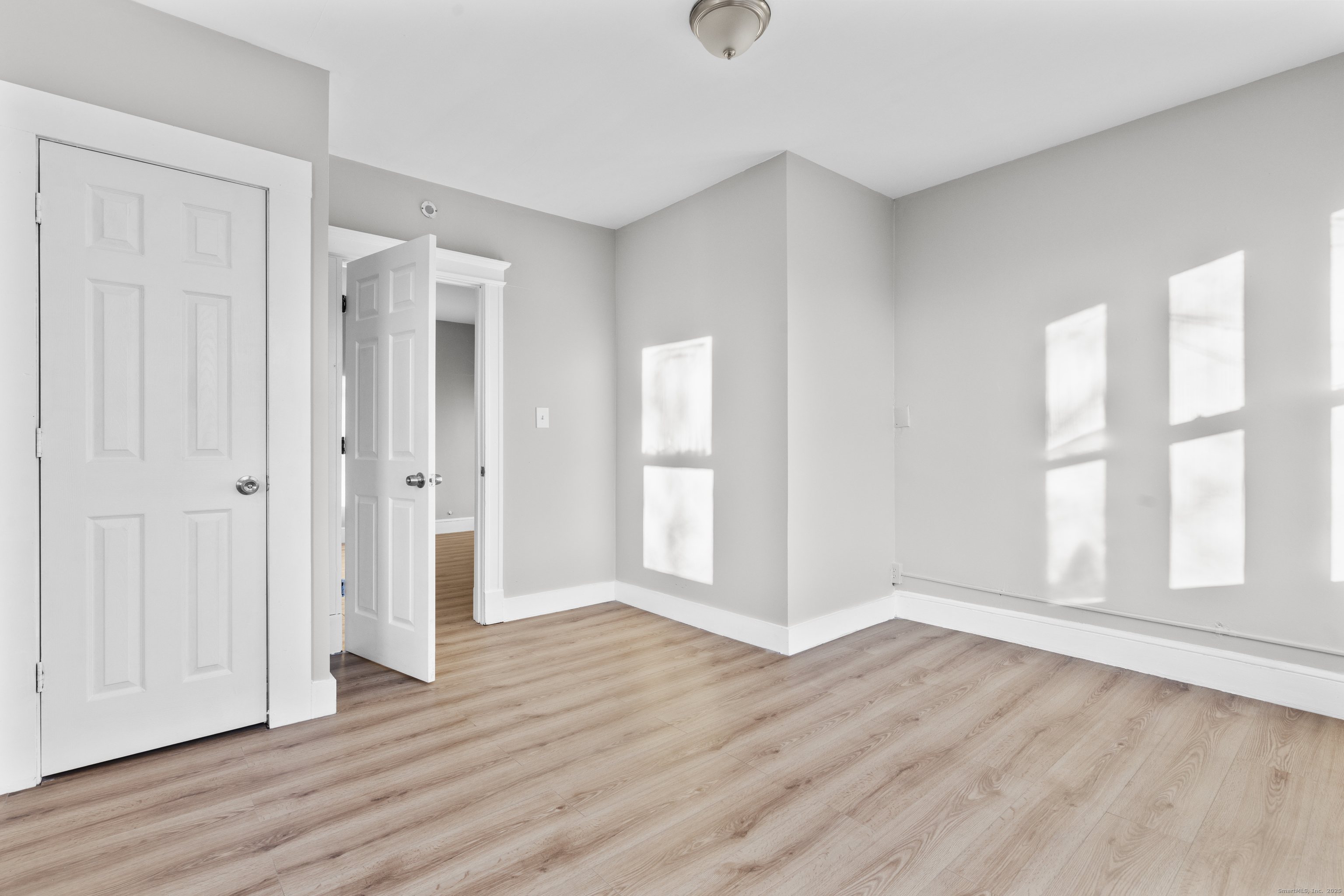 141 Draher Street Waterbury, CT 06708 - Photo 10 of 20 an empty room with wooden floor and windows