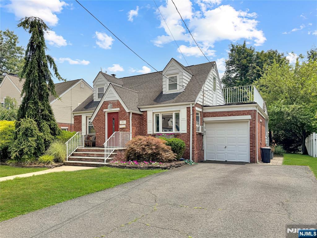 11-02 Charles Street Fair Lawn, NJ 07410 - Photo 2 of 15 a front view of a house with a garden