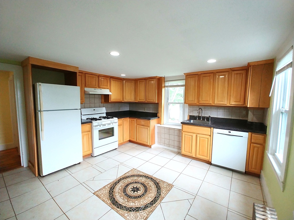 a kitchen with a refrigerator a stove top oven a sink and cabinets
