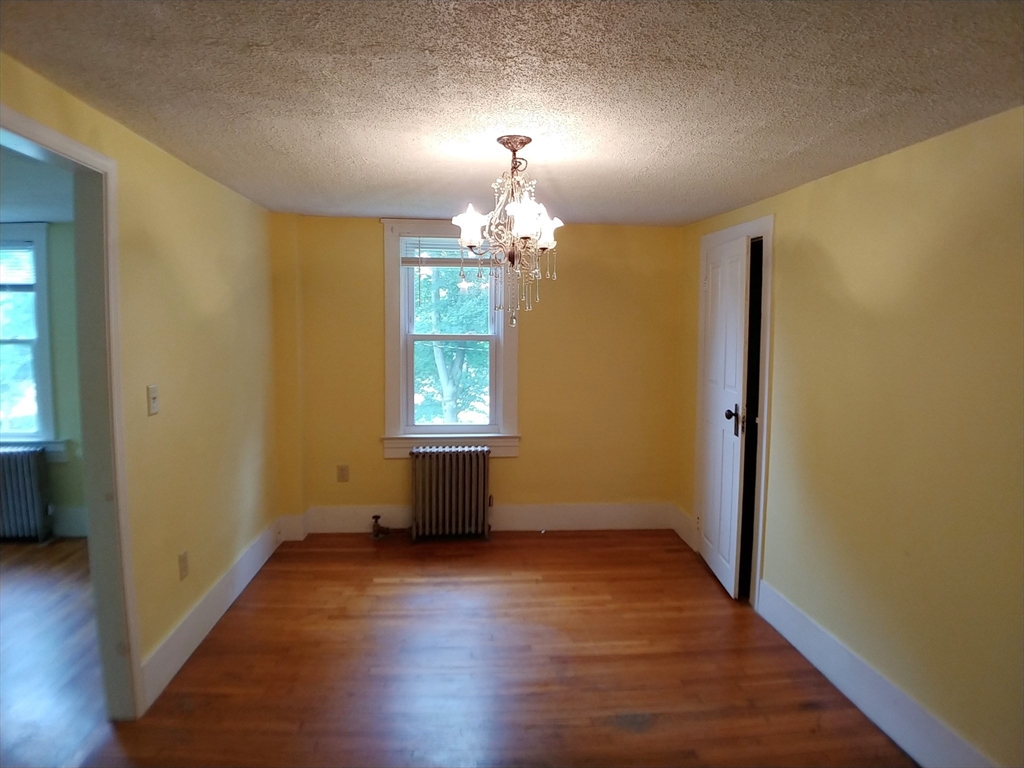 77 Hudson Street, Unit 2 Marlborough, MA 01752 - Photo 12 of 30 an empty room with wooden floor chandelier and windows