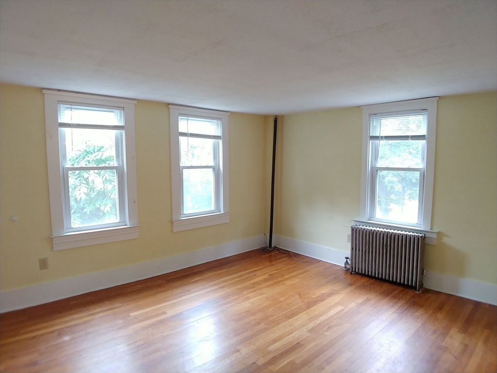 77 Hudson Street, Unit 2 Marlborough, MA 01752 - Photo 15 of 30 a view of an empty room with wooden floor and a window