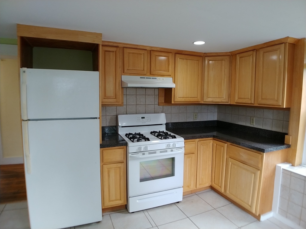 77 Hudson Street, Unit 2 Marlborough, MA 01752 - Photo 2 of 30 a kitchen with a stove and a refrigerator