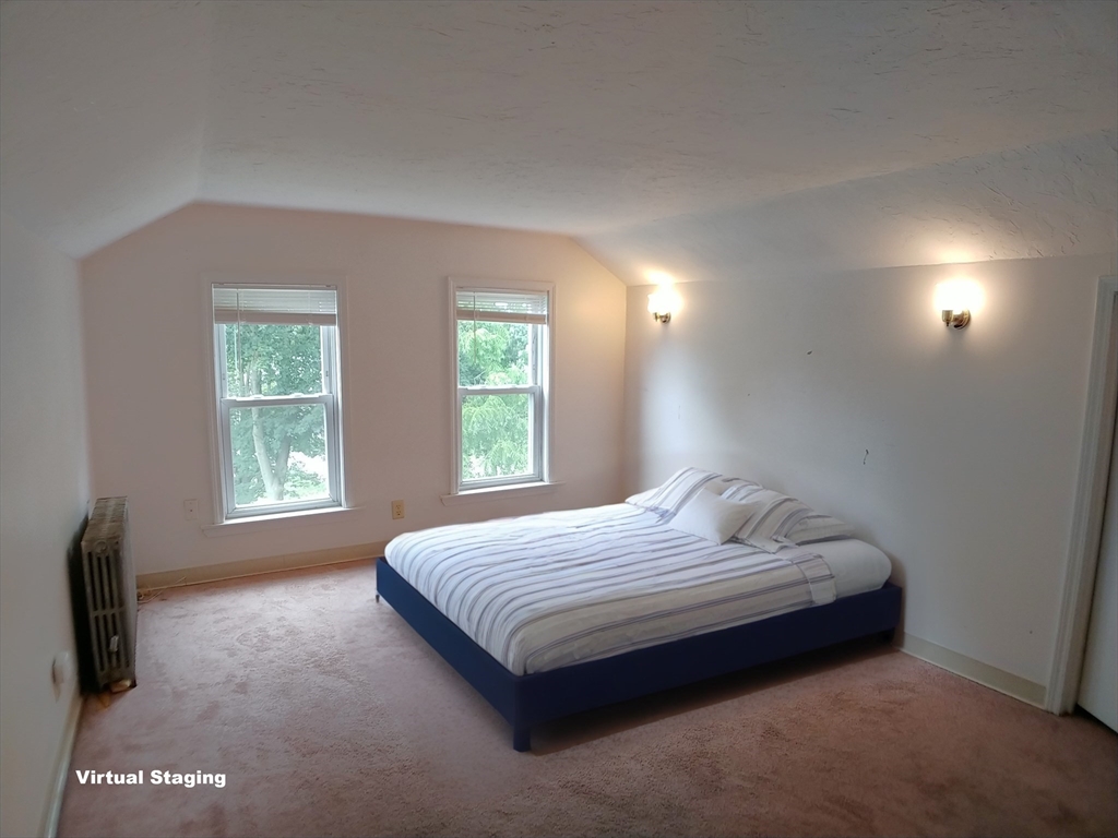 77 Hudson Street, Unit 2 Marlborough, MA 01752 - Photo 25 of 30 a bedroom with a bed and a tv on table