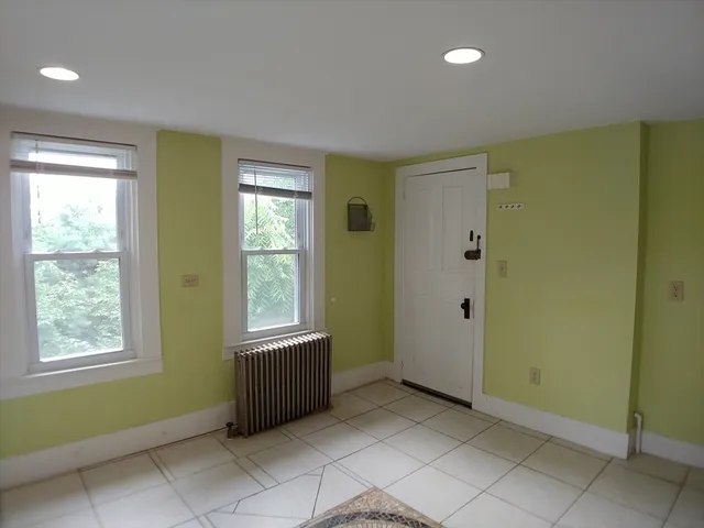 a view of an empty room with window and bathroom