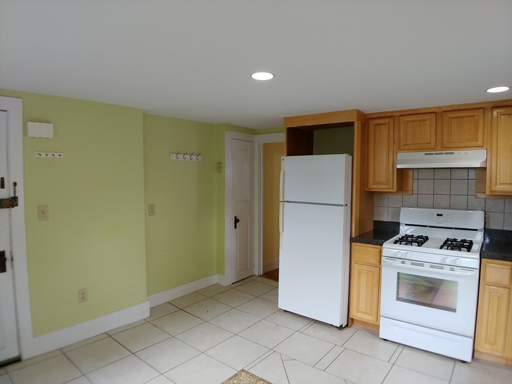 77 Hudson Street, Unit 2 Marlborough, MA 01752 - Photo 5 of 30 a kitchen with a refrigerator and a stove top oven