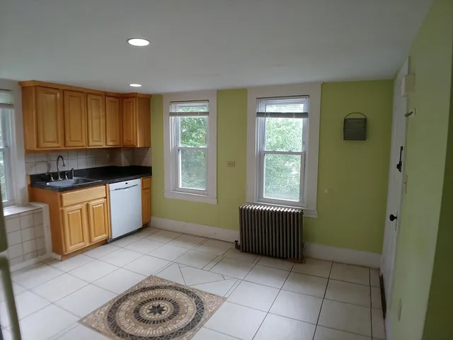 a kitchen with granite countertop a stove a sink and a window