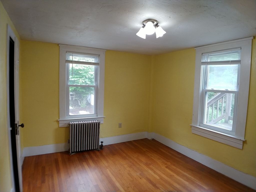 77 Hudson Street, Unit 2 Marlborough, MA 01752 - Photo 7 of 30 a view of an empty room with a window and wooden floor