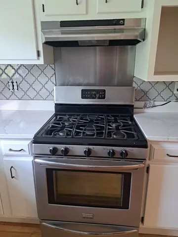 a stove top oven sitting inside of a kitchen