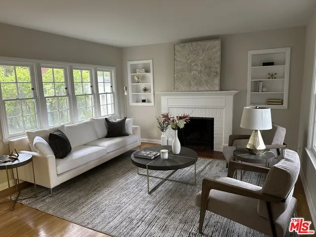 a living room with furniture fireplace and a large window
