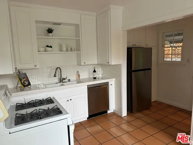 a kitchen with a refrigerator sink and cabinets