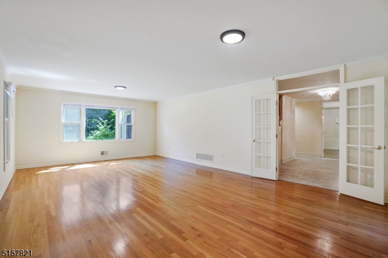 22 Court Road Morris Plains, NJ 07950 - Photo 4 of 28 an empty room with wooden floor cabinet and windows