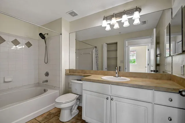 a bathroom with a granite countertop sink a toilet and shower