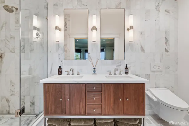 a bathroom with a sink a toilet and shower