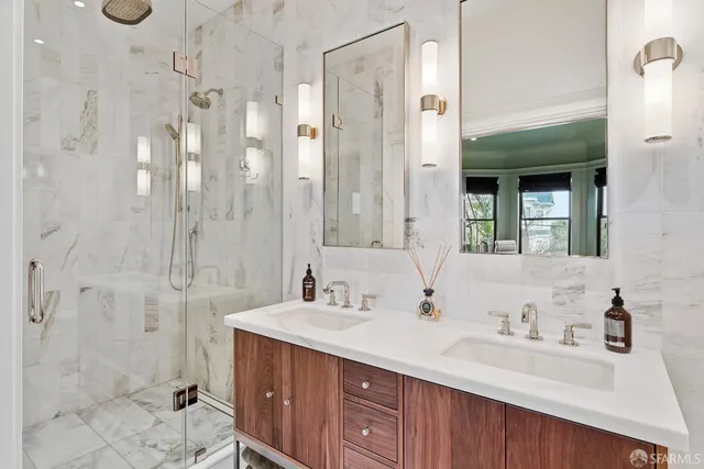 a bathroom with a double vanity sink mirror and shower