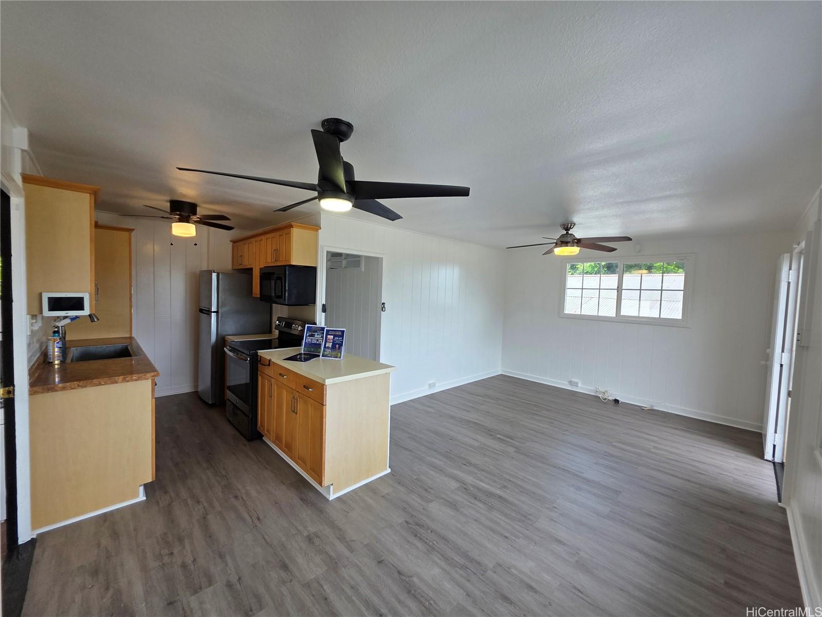 45-557 Keaahala Road, Unit K Kaneohe, HI 96744 - Photo 3 of 20 a kitchen with stainless steel appliances granite countertop a sink dishwasher a refrigerator and a stove with wooden floors