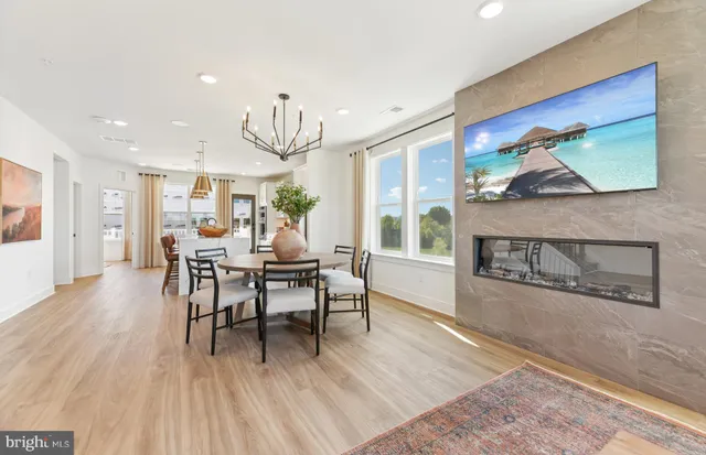 a dining room with wooden floor a glass table and chairs