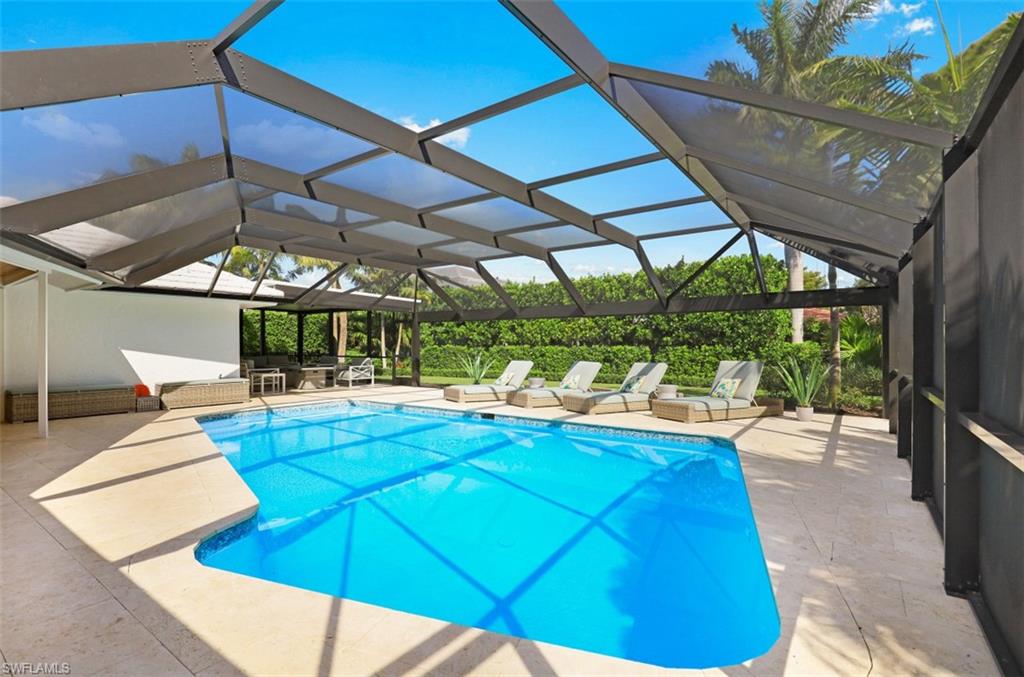 549 Neapolitan Way Naples, FL 34103 - Photo 4 of 35 a view of a backyard with table and chairs under an umbrella