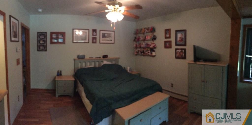 230 Deans Rhode Hall Road Monroe Township, NJ 08831 - Photo 5 of 11 a bedroom with a bed and a chandelier