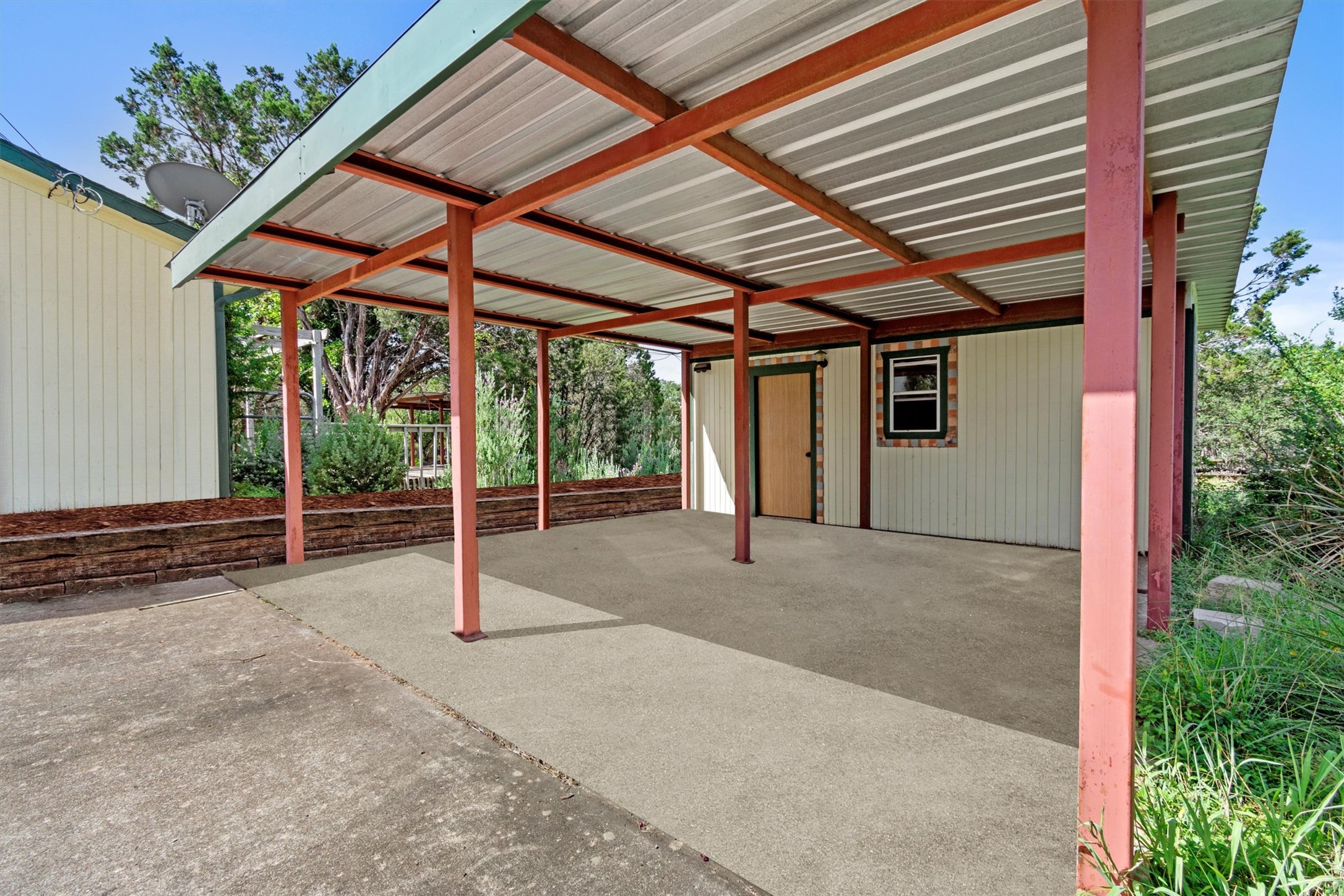 6 El Sol Road Wimberley, TX 78676 - Photo 19 of 20 A robust metal carport offers sheltered parking and additional outdoor space.