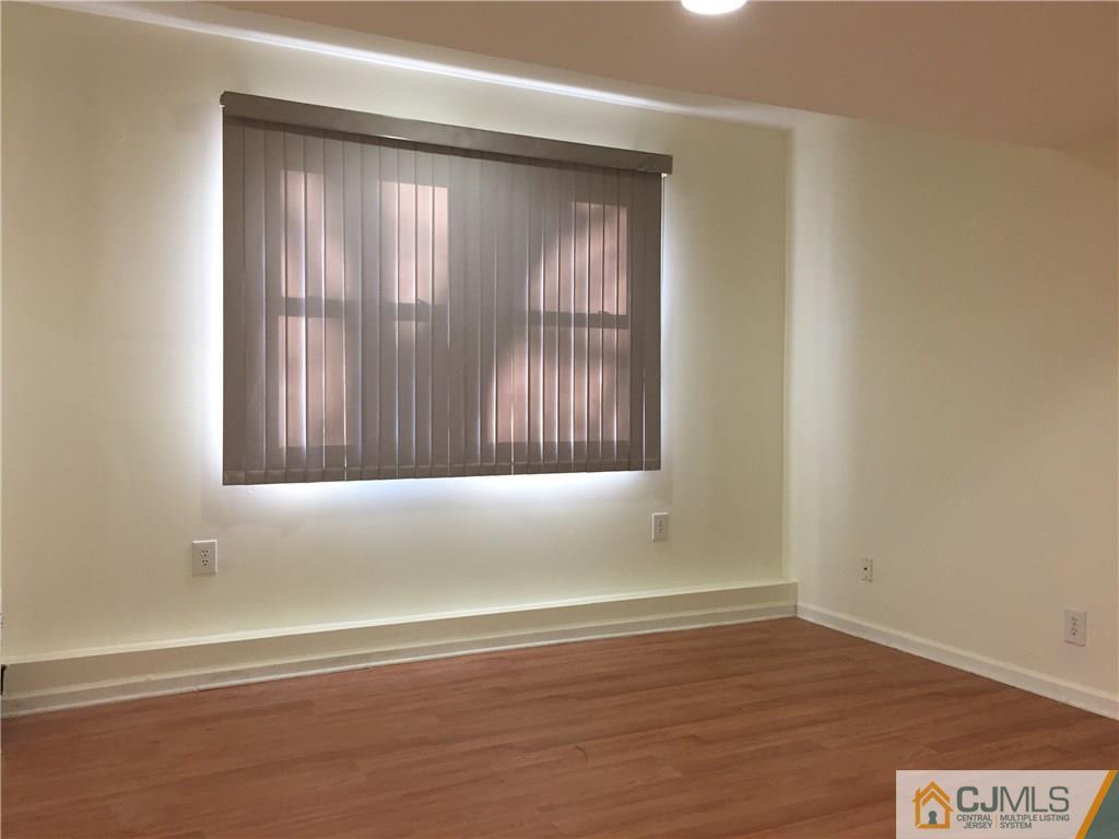 65 Idlewild Road Edison, NJ 08817 - Photo 17 of 21 a view of an empty room with wooden floor and a window