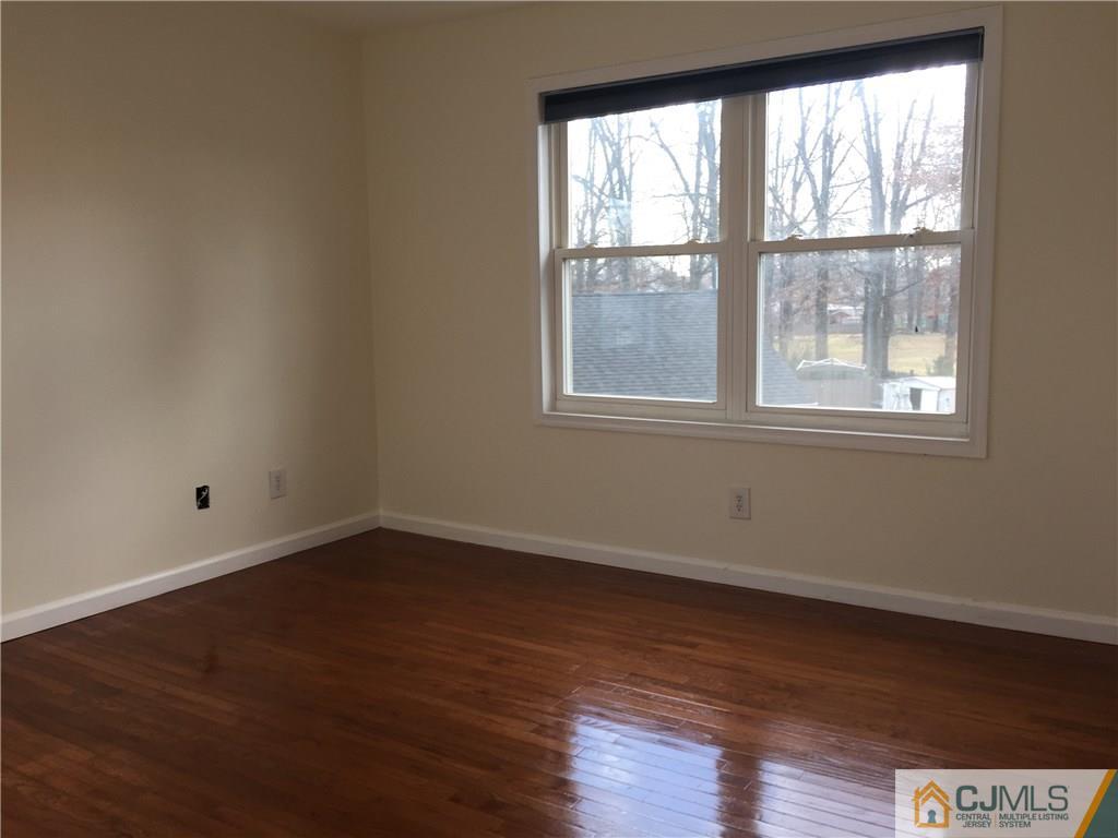 65 Idlewild Road Edison, NJ 08817 - Photo 19 of 21 an empty room with wooden floor and windows