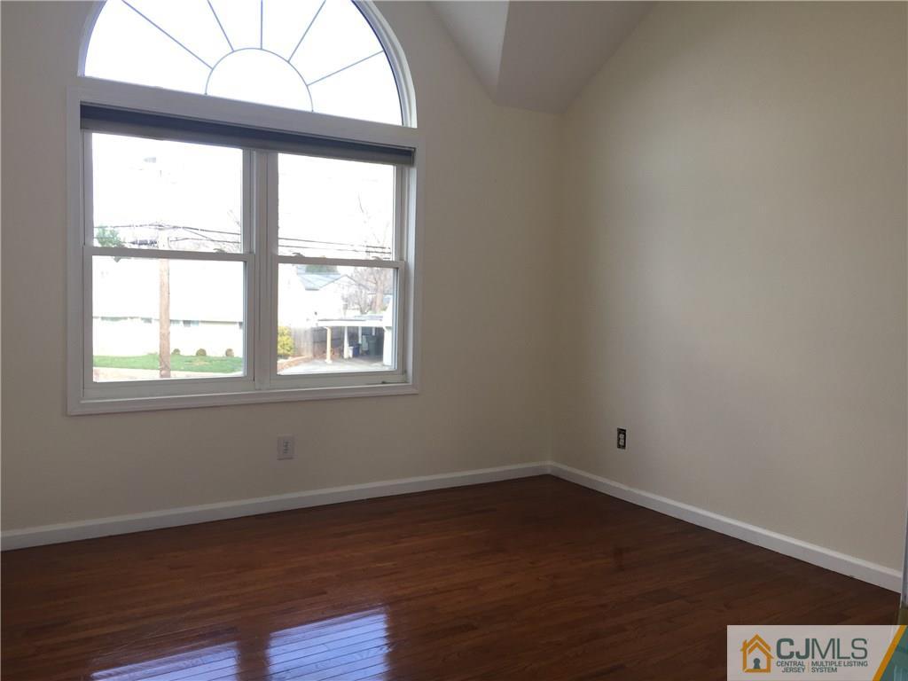 65 Idlewild Road Edison, NJ 08817 - Photo 20 of 21 an empty room with wooden floor and windows