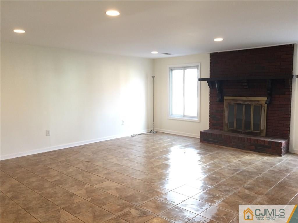 65 Idlewild Road Edison, NJ 08817 - Photo 7 of 21 a view of empty room with wooden floor and fireplace