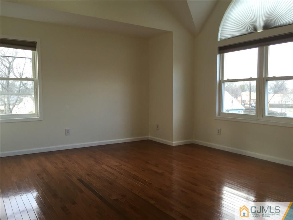 65 Idlewild Road Edison, NJ 08817 - Photo 10 of 21 an empty room with wooden floor and windows