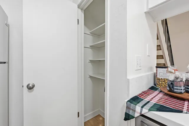 a kitchen with white cabinets and appliances