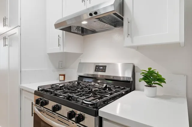a view with a sink a counter space and cabinets