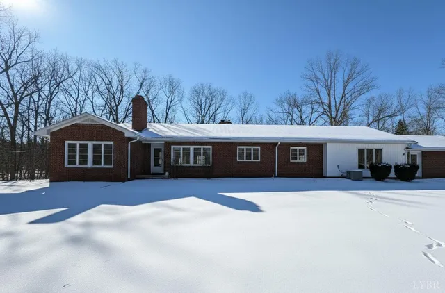 a view of house with yard and trees in the background