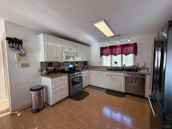 a kitchen with granite countertop white cabinets and stainless steel appliances