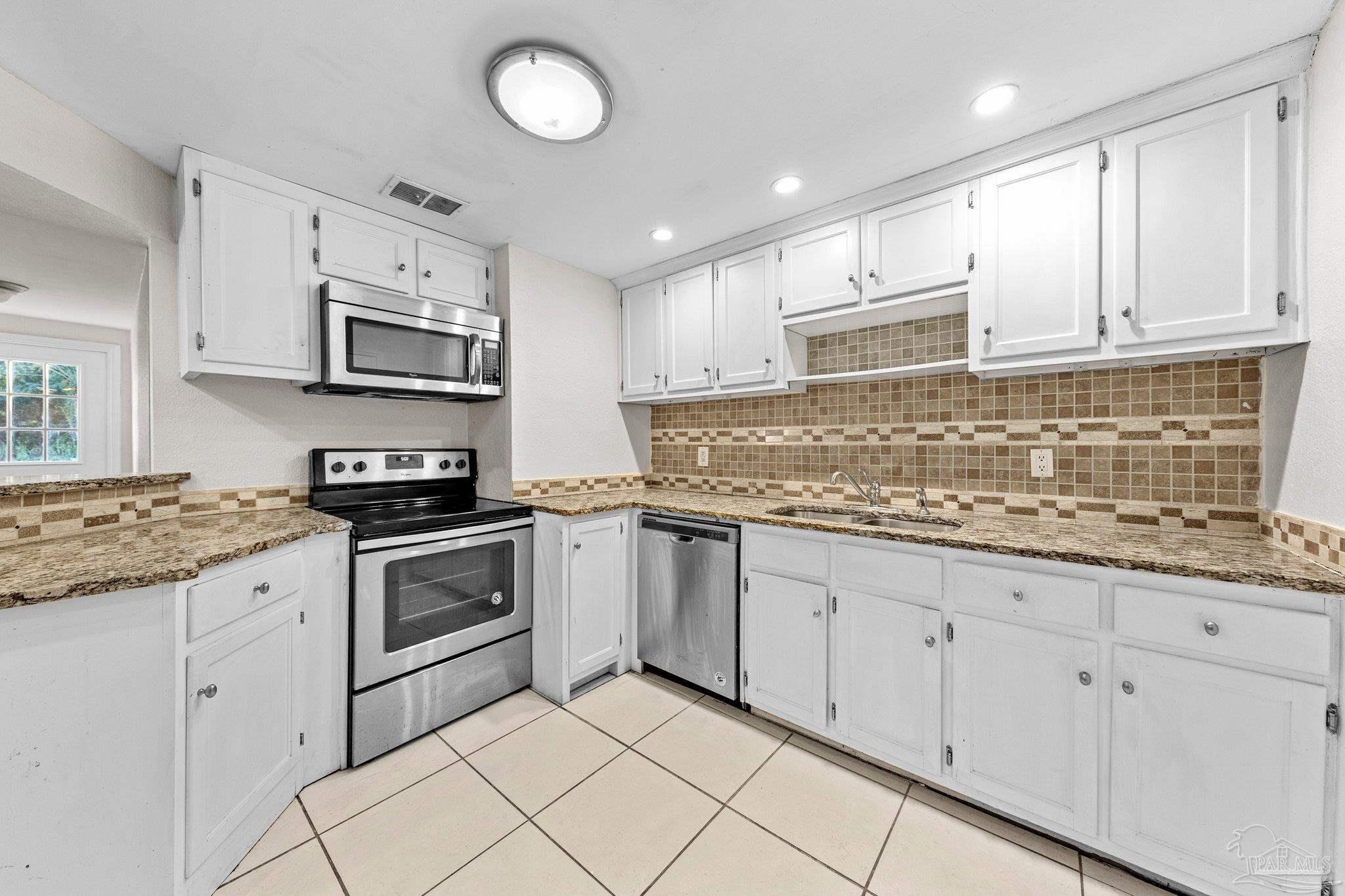 162 West Burgess Road Pensacola, FL 32503 - Photo 11 of 30 a kitchen with stainless steel appliances granite countertop a sink and cabinets
