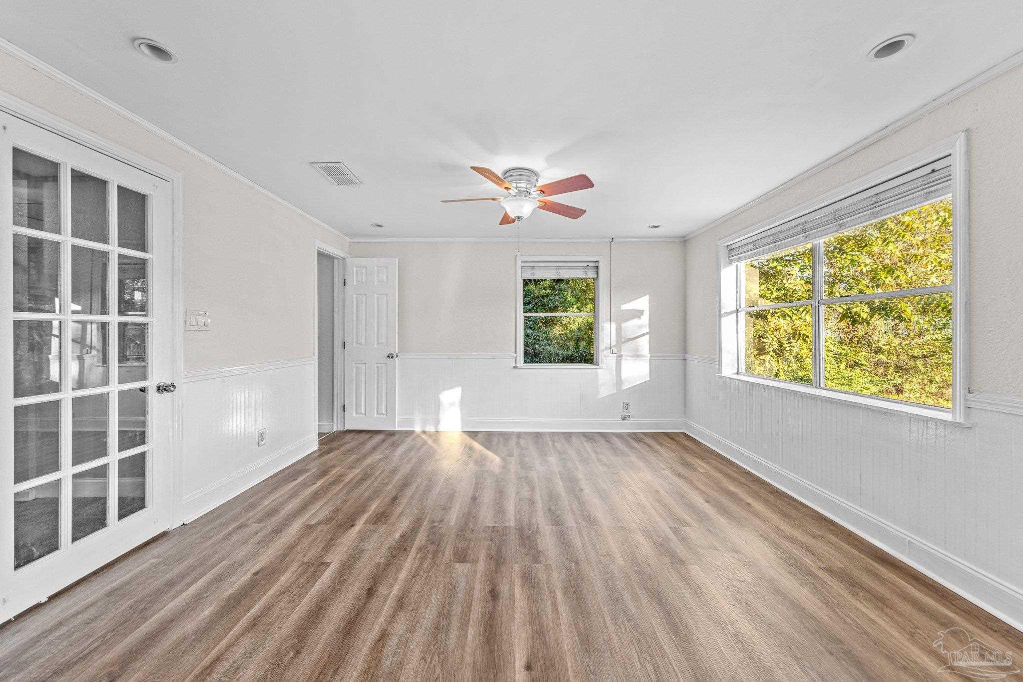 162 West Burgess Road Pensacola, FL 32503 - Photo 15 of 30 a view of an empty room with a window and wooden floor
