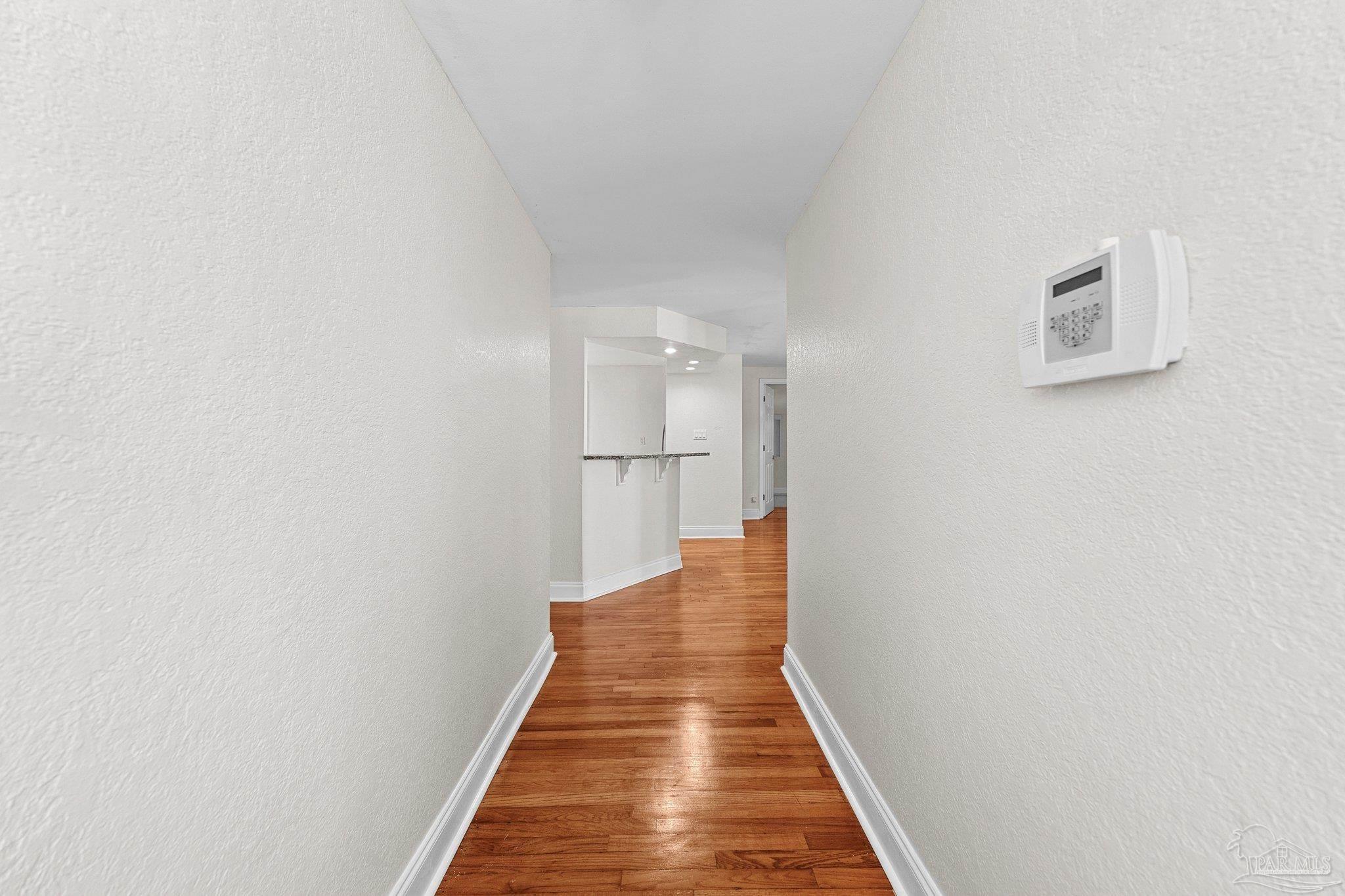 162 West Burgess Road Pensacola, FL 32503 - Photo 4 of 30 a view of a hallway with wooden floor and a white wall