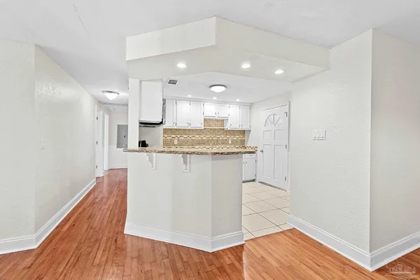 a large kitchen with stainless steel appliances granite countertop a refrigerator and a stove top oven