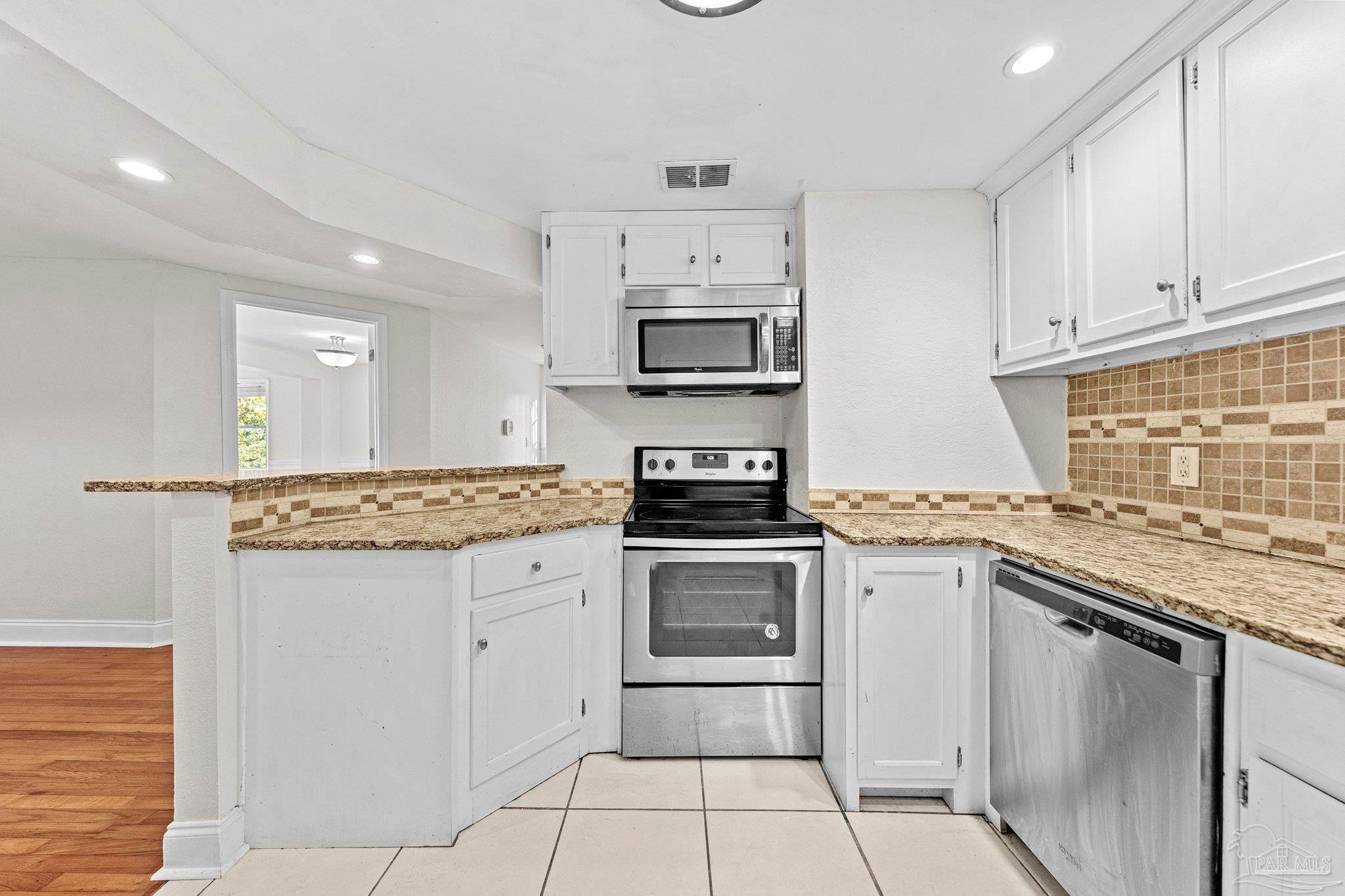 162 West Burgess Road Pensacola, FL 32503 - Photo 9 of 30 a kitchen with stainless steel appliances granite countertop a stove top oven microwave and cabinets