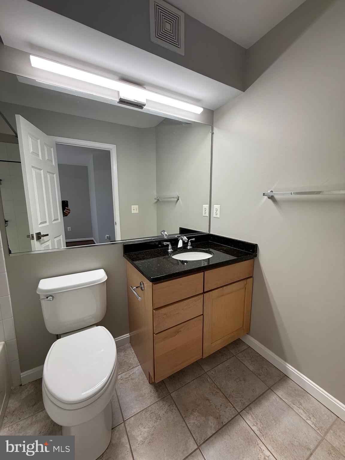 12108 Kinsley Place Reston, VA 20190 - Photo 14 of 17 a bathroom with a granite countertop toilet sink and mirror
